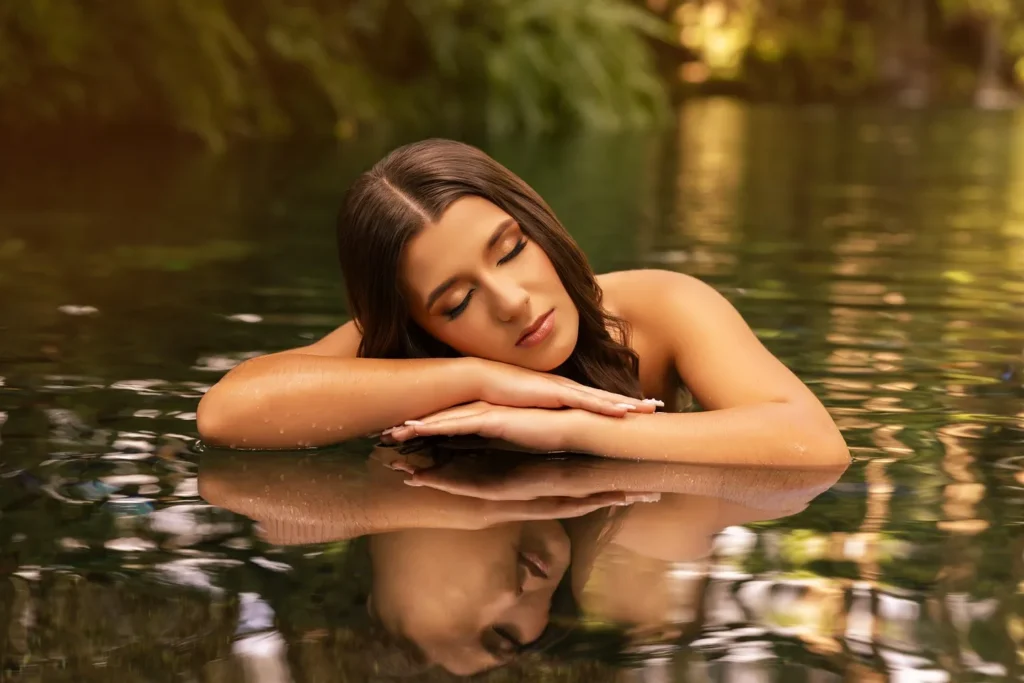 Quinceañera descansando en el agua con reflejo perfecto y fondo natural